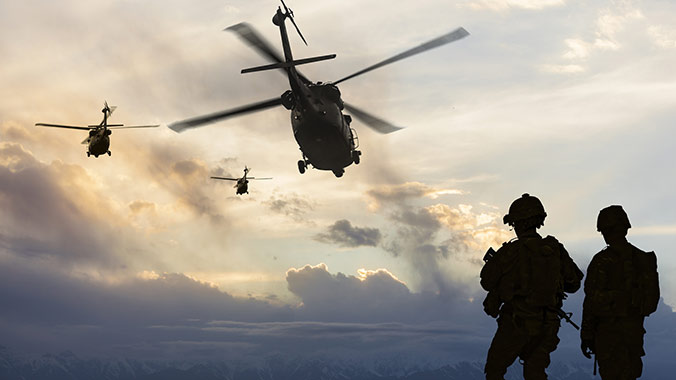 Soldiers walking and helicopters hovering in sky